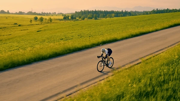 A peaceful countryside cycling scene representing the breath cycle in motion